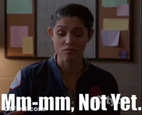A Woman Is Standing In Front Of A Bulletin Board And Says Mm-Mm Not Yet . GIF