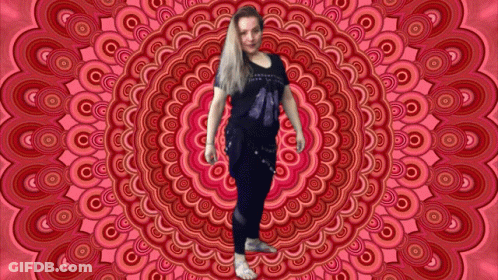 A Woman Is Standing In Front Of A Circular Pattern GIF