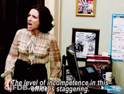 A Woman Is Standing In Front Of A Computer With The Words " The Level Of Incompetence In This Office Is Staggering " Abo GIF