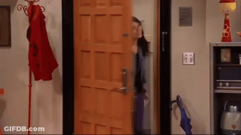 A Woman Is Standing In Front Of A Door That Says ' Amanda ' On It .. GIF
