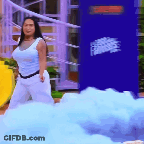 A Woman Is Standing In Front Of A Fantastics Advertisement GIF