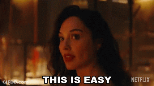 A Woman Is Standing In Front Of A Fire And Saying `` This Is Easy '' . GIF
