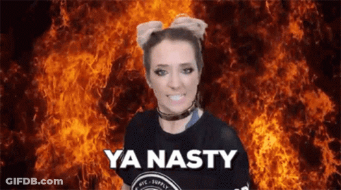 A Woman Is Standing In Front Of A Fire And Says Ya Nasty GIF