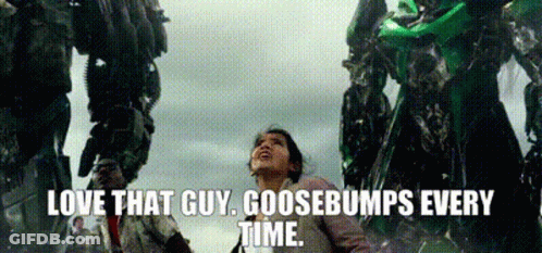 A Woman Is Standing In Front Of A Giant Robot And Says `` Love That Guy Goosebumps Every Time '' . GIF