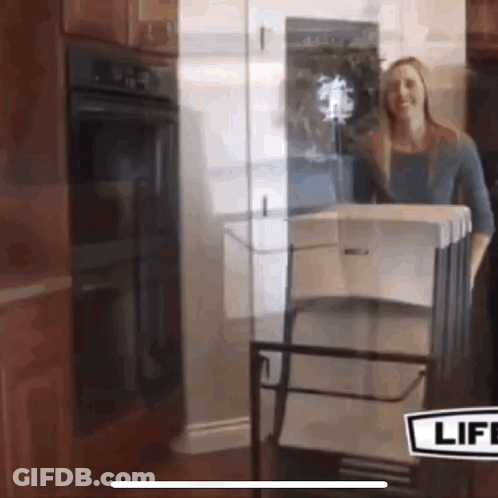 A Woman Is Standing In Front Of A Glass Door With A Sign That Says Life GIF