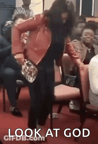A Woman Is Standing In Front Of A Group Of People And Holding A Purse In Her Hand . GIF