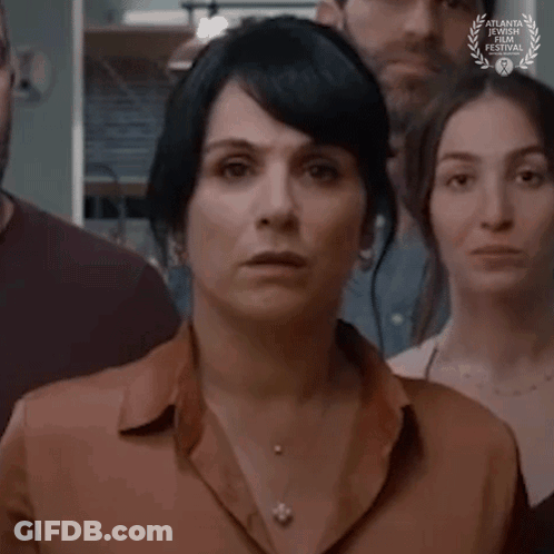 A Woman Is Standing In Front Of A Group Of People With A Laurel Wreath On Her Neck . GIF