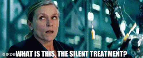 A Woman Is Standing In Front Of A Machine And Asking What Is This The Silent Treatment ? GIF