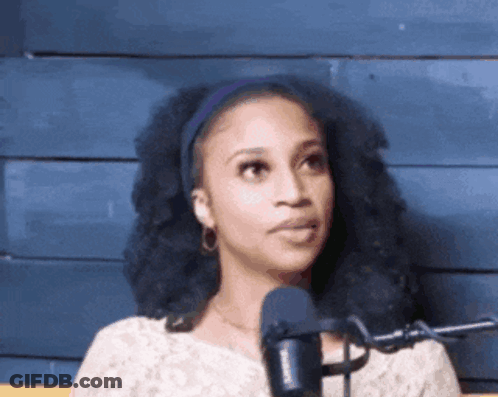 A Woman Is Standing In Front Of A Microphone And Making A Funny Face GIF