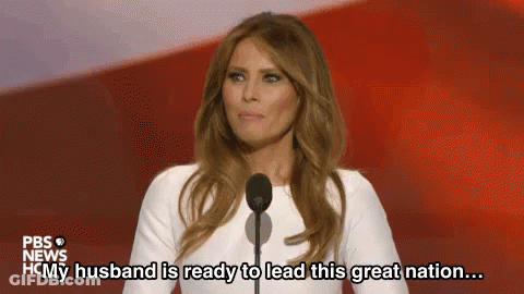 A Woman Is Standing In Front Of A Microphone And Saying `` My Husband Is Ready To Lead This Great Nation ... '' . GIF