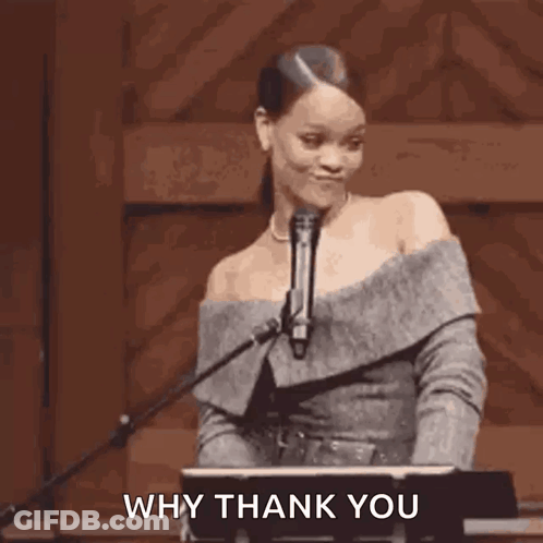 A Woman Is Standing In Front Of A Microphone Holding Her Hair In A Ponytail . GIF