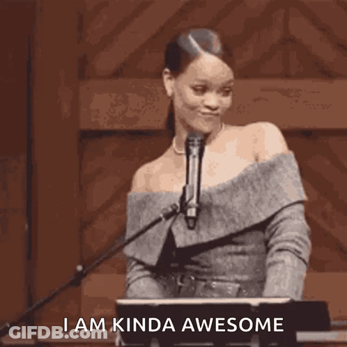 A Woman Is Standing In Front Of A Microphone With The Words `` I Am Kinda Awesome '' Written Below Her . GIF