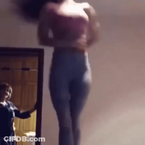 A Woman Is Standing In Front Of A Mirror And Taking A Picture Of Herself GIF