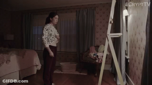 A Woman Is Standing In Front Of A Mirror In A Bedroom With #Crypttv Written On The Bottom Right Corner GIF