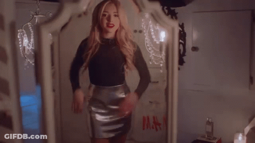 A Woman Is Standing In Front Of A Mirror With A Bag That Says H & M On It GIF