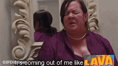 A Woman Is Standing In Front Of A Mirror With The Words It 'S Coming Out Of Me Like Lava Above Her GIF
