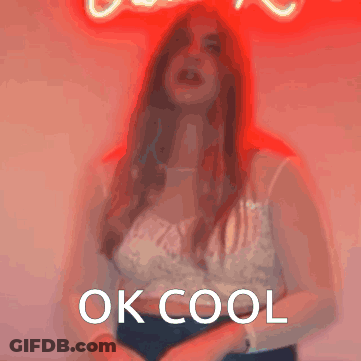 A Woman Is Standing In Front Of A Neon Sign That Says " Ok Cool " GIF
