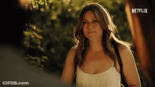 A Woman Is Standing In Front Of A Netflix Ad GIF