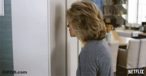 A Woman Is Standing In Front Of A Netflix Sign GIF