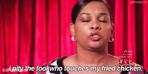 A Woman Is Standing In Front Of A Red Curtain And Says I Pity The Fool Who Touches My Fried Chicken . GIF