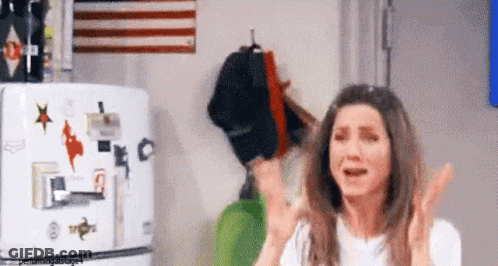 A Woman Is Standing In Front Of A Refrigerator With Stickers On It And Crying . GIF
