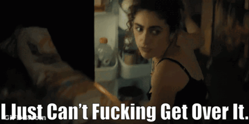 A Woman Is Standing In Front Of A Refrigerator With The Words " I Just Can 'T Fucking Get Over It " Below Her GIF