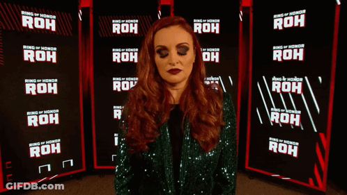 A Woman Is Standing In Front Of A Ring Of Honor Banner GIF