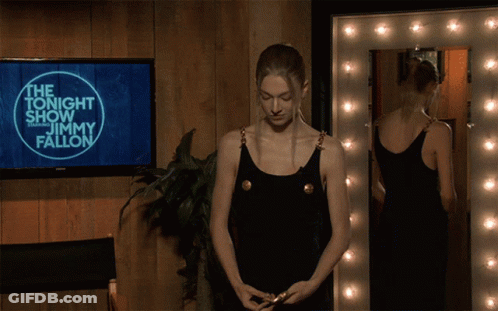 A Woman Is Standing In Front Of A Screen That Says Jimmy Fallon GIF
