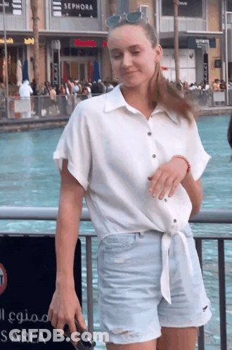 A Woman Is Standing In Front Of A Sephora Sign GIF
