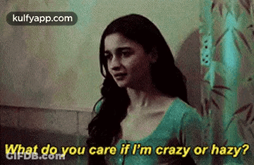 A Woman Is Standing In Front Of A Shower Curtain And Talking To Someone . GIF