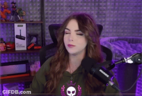 A Woman Is Standing In Front Of A Shure Microphone And Pointing GIF