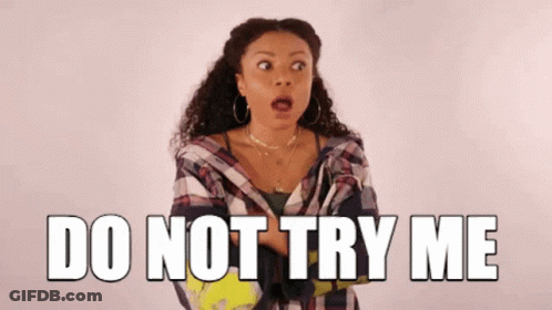 A Woman Is Standing In Front Of A Sign That Says Do Not Try Me GIF