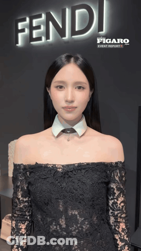 A Woman Is Standing In Front Of A Sign That Says Fendi GIF