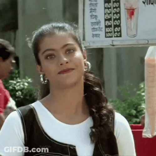 A Woman Is Standing In Front Of A Sign That Says ' Juice ' On It GIF