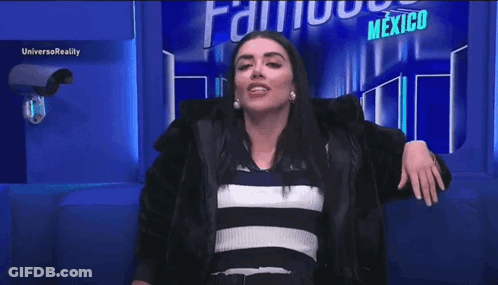 A Woman Is Standing In Front Of A Sign That Says Mexico On It . GIF