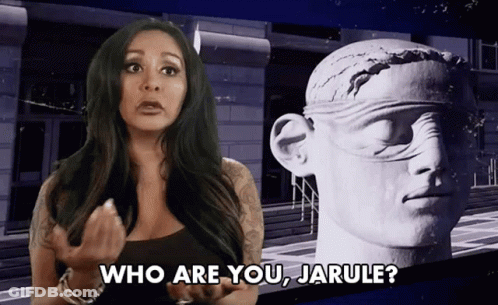 A Woman Is Standing In Front Of A Statue And Asking Who Are You Jarule GIF