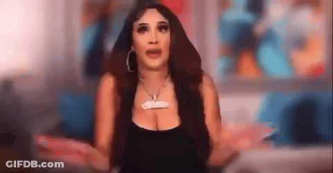 A Woman Is Standing In Front Of A Television With Her Arms Outstretched And A Necklace On Her Neck . GIF