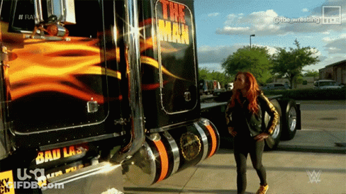 A Woman Is Standing In Front Of A Truck That Says The Man GIF
