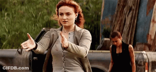A Woman Is Standing In Front Of A Truck With Her Arms Outstretched In A Karate Pose . GIF