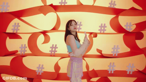 A Woman Is Standing In Front Of A Wall Of Hashtags GIF