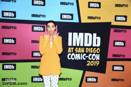 A Woman Is Standing In Front Of A Wall That Says Imdb At San Diego Comic-Con 2019 GIF