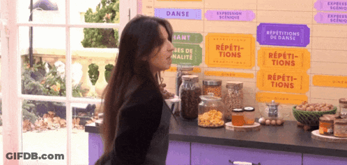 Woman Standing In Front Of Repetitions De Danse Sign GIF