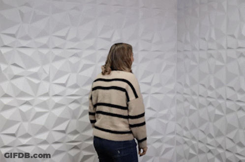 A Woman Is Standing In Front Of A White Wall And Says Oh Snap GIF