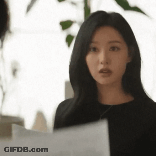 A Woman Is Standing In Front Of A Window Holding A Piece Of Paper . GIF