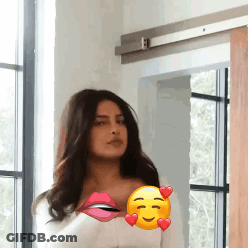 A Woman Is Standing In Front Of A Window With A Smiley Face On Her Chest GIF