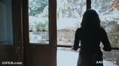 A Woman Is Standing In Front Of A Window With The Words Made In Animotica On The Bottom GIF