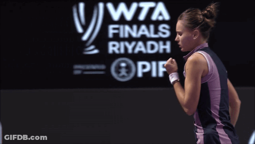 A Woman Is Standing In Front Of A Wta Finals Riyadh Sign GIF