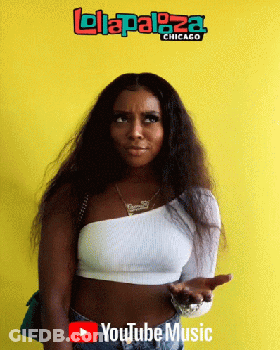 A Woman Is Standing In Front Of A Yellow Wall That Says Lolapaloza Chicago GIF