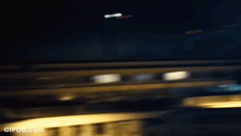 A Woman Is Standing In The Dark Wearing A Ripped Shirt And Black Pants . GIF