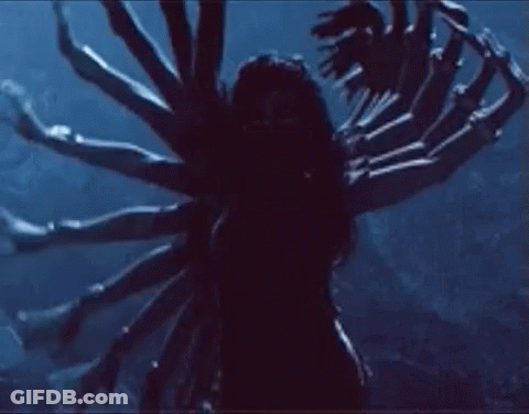 A Woman Is Standing In The Dark With A Bunch Of Arms . GIF